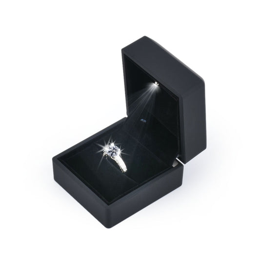 Open black LED light ring box displaying a solitaire ring