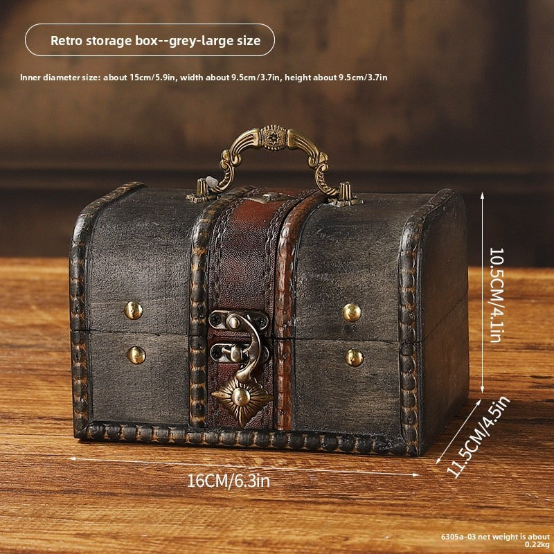 Distressed gray wooden chest with ornate handle and curved latch