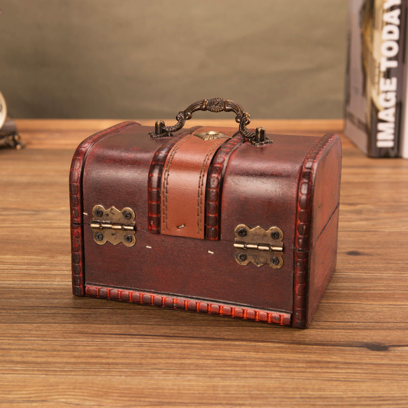Back of reddish brown wooden chest showing two brass hinges and carry handle