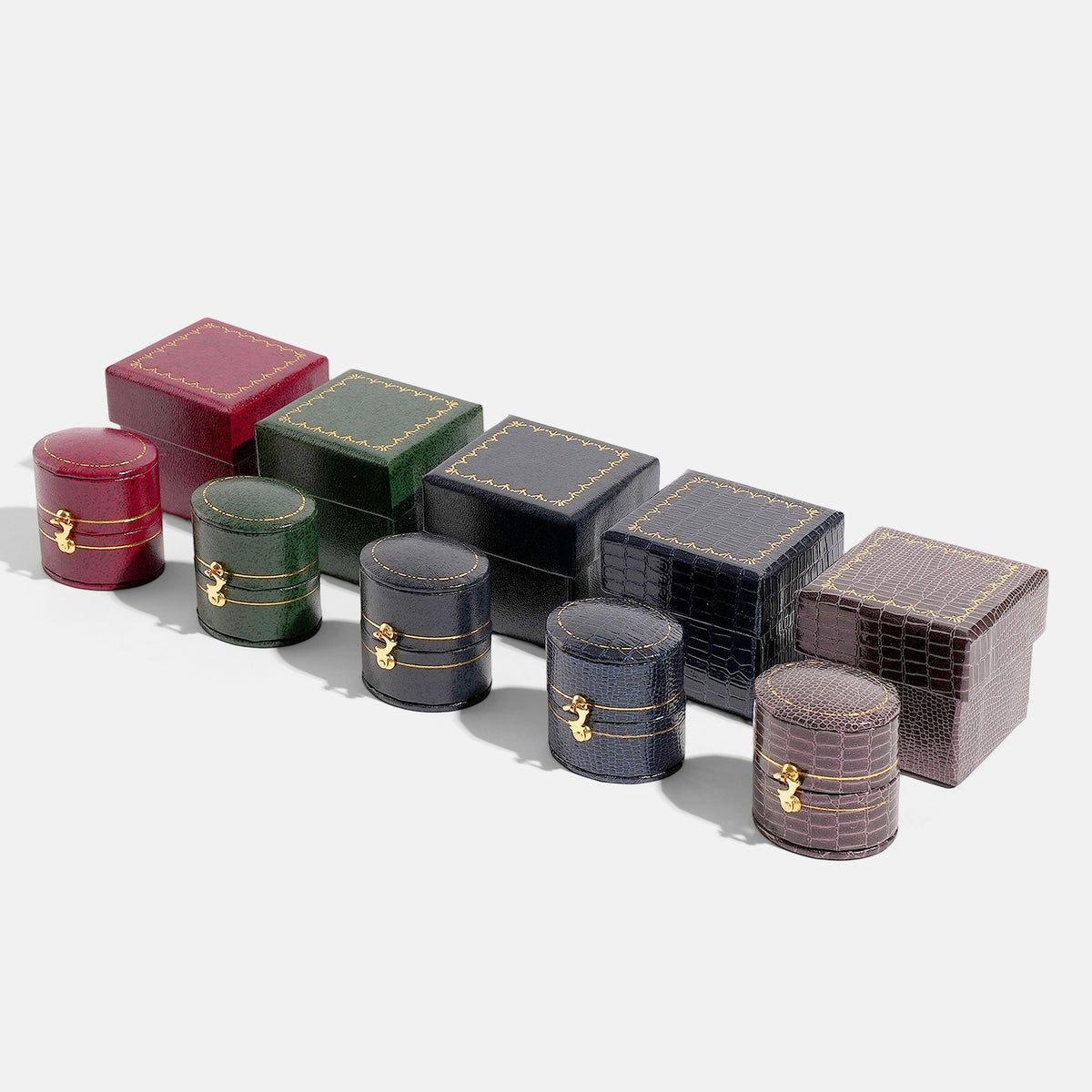 Five closed oval jewelry boxes and five square boxes in assorted colors and textures