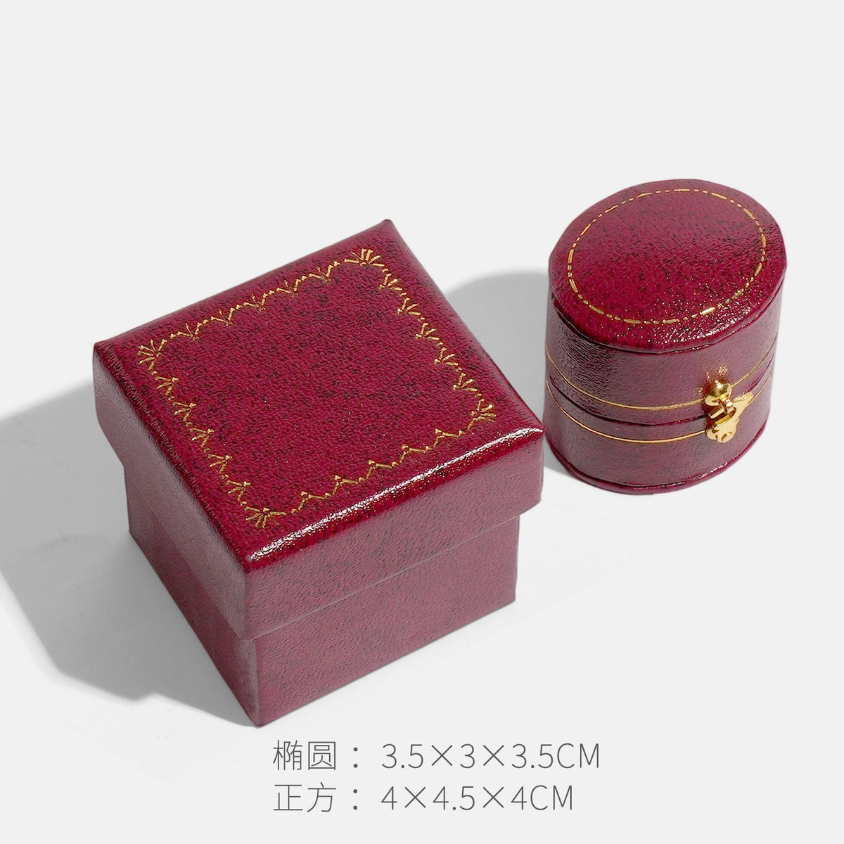 Burgundy red oval clasp jewelry box beside a square box with gold border decoration