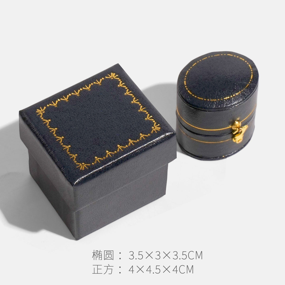 Plain dark navy blue oval clasp jewelry box beside a square box with gold border decoration