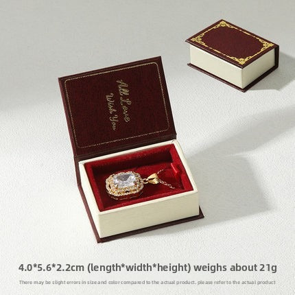 Burgundy book-shaped pendant box with red insert and matching closed box on white