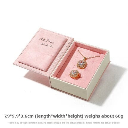 Open pink book-shaped jewelry set box showing lid cushion and empty insert on white